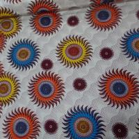tissu wax blanc imprimé soleil ton bordeaux ,orange ,jaune ,bleu