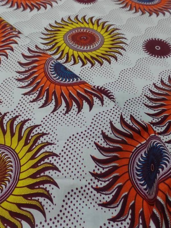 tissu wax blanc imprimé soleil ton bordeaux ,orange ,jaune ,bleu